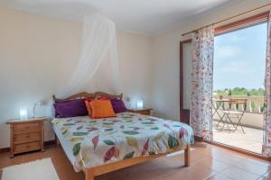 a bedroom with a bed and a large window at Can Cancus in Capdepera
