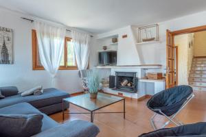 a living room with a couch and a fireplace at Can Cancus in Capdepera