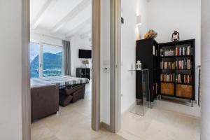 a bedroom with a bed and a book shelf with books at Eco del Garda Apartments in Tenno