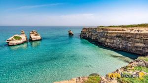 a group of rocks in the water near the ocean at Casa Vacanze Kalocéri in Torre dell'Orso
