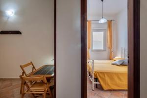 a room with a bed and a table with a laptop at Casa Vacanze Kalocéri in Torre dell'Orso