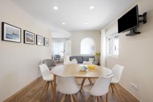 a dining room with a table and white chairs at Pontes Guest House in Arcozelo