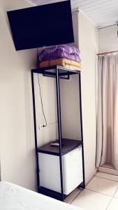 a black shelf with a tv on top of it at Hotel América in Ivaiporã
