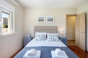 a bedroom with a bed with two towels on it at Pontes Guest House in Arcozelo +36 photos