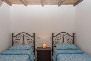 a bedroom with two beds and a lamp on a night stand at Villa Marisa in Budoni