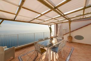 a dining room with a table and chairs on a balcony at Villa Domus Augusto in Conca dei Marini