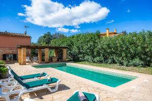 a swimming pool with chairs and a villa at Ses Oliveres en Port Verd in Son Servera