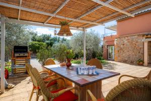 a patio with a table and chairs and a grill at Ses Oliveres en Port Verd in Son Servera