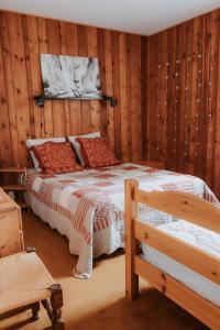 a bedroom with a bed in a room with wooden walls at Jean Pierre Skilodge in La Toussuire