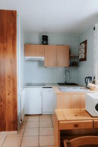 a kitchen with white appliances and wooden cabinets at Jean Pierre Skilodge in La Toussuire
