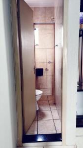 a bathroom with a toilet and a shower at Hotel América in Ivaiporã +4 photos