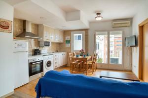 a kitchen with a table and a blue couch in a room at Apartament Luisa in Lloret de Mar