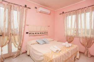 a bedroom with a bed and two windows at Villa erica appartamento Cindy in Villa San Pietro