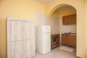 a kitchen with a white refrigerator and an open door at Villa erica appartamento Cindy in Villa San Pietro +17 photos