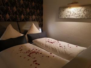 a room with two beds with red petals on the sheets at Wohlfühloase Ermreuth in Neunkirchen am Brand +37 photos