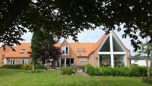 a house with a large window and a roof at Art Apartment Sønderbygaard in Vinderup