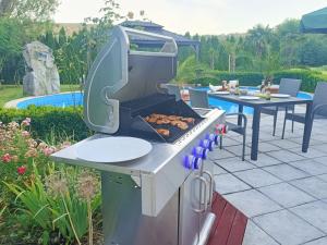 a barbecue grill with food cooking on a patio at Wohlfühloase Ermreuth in Neunkirchen am Brand