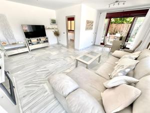 a white living room with a couch and a tv at Villa with Private Pool in Estepona