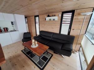 a living room with a couch and a table at Hausboot Geiselruh in Braunsbedra