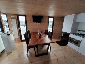 a kitchen and dining room with a wooden table and chairs at Hausboot Geiselruh in Braunsbedra