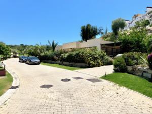 a cobblestone driveway with a car parked on a street at Villa with Private Pool in Estepona