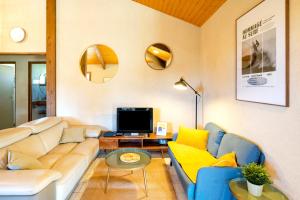 a living room with a couch and a tv at Chardons bleus - villa 6p in Capbreton