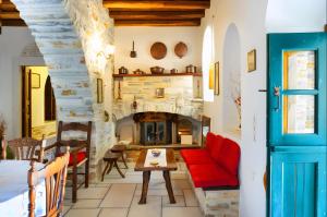 a living room with a red couch and a fireplace at Zeus House in Naxos Chora