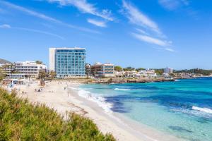a beach with people on the sand and the ocean at Es Claper in Cala Ratjada