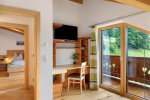 a room with a desk and a sliding glass door at Ferienwohnung Haus Brugger in Uttendorf +25 photos