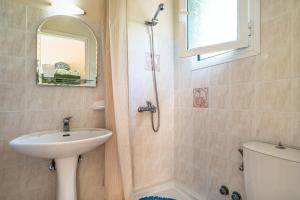 a bathroom with a sink and a toilet and a mirror at Anemona apartment 2 in Kefallonia +12 photos