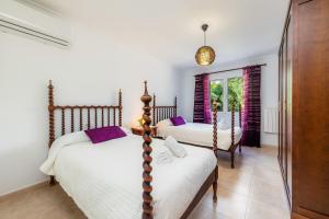 a bedroom with two beds and a window at Es Claper in Cala Ratjada