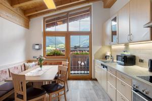 a kitchen with a table and a window and a table and chairs at Ferienwohnung Haus Brugger in Uttendorf