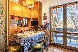 a dining room with a table and chairs and a window at Ciasa Apelli in Pozza di Fassa