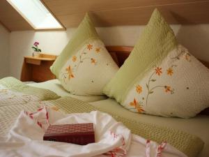 a bed with two pillows and a book on it at Haus Margot Armbruster in Bad Rippoldsau-Schapbach