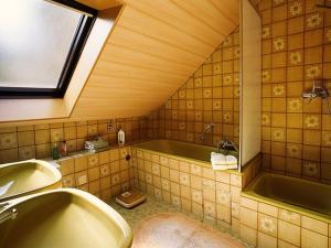 a bathroom with a tub and a sink and a window at Haus Margot Armbruster in Bad Rippoldsau-Schapbach +7 photos