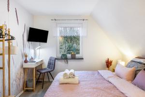 a bedroom with a bed and a desk and a window at Ferienhaus Kirsch in Blankenhain