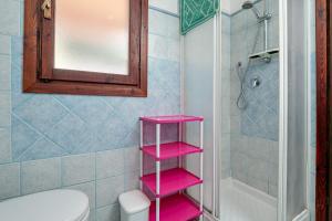 a bathroom with a pink shelf in a bathroom at Villetta i Gerani in San Teodoro +13 photos