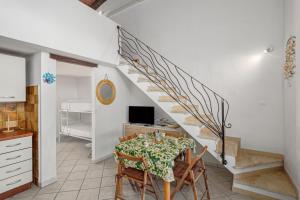 a dining room with a table and a staircase at Villetta i Gerani in San Teodoro