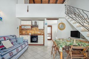 a kitchen and living room with a table and a couch at Villetta i Gerani in San Teodoro