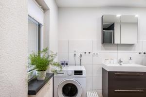 a white bathroom with a washing machine in it at Ferienhaus Kirsch in Blankenhain +27 photos