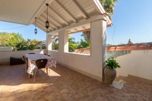 a patio with a table and a vase at Saija Apartment con piscina in Pozzallo