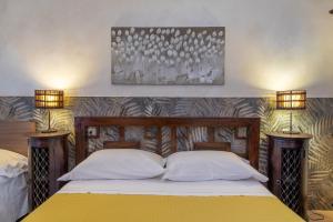 a bedroom with a bed with two lights on the wall at Saija Apartment con piscina in Pozzallo