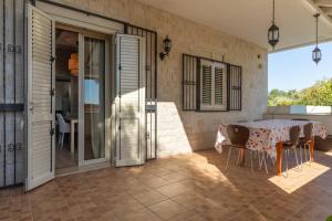 a dining room with a table and chairs on a patio at Saija Apartment con piscina in Pozzallo