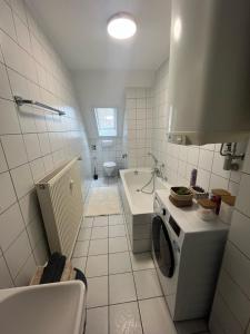 a white bathroom with a sink and a stove at Charmante Altbauwohnung in Erlangen +12 photos