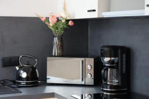 a vase of flowers sitting on top of a microwave at Charmante Altbauwohnung in Erlangen