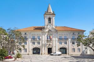 a building with a clock tower and a car parked in front at Aveiro City Blue in Aveiro