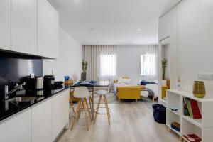 a kitchen and living room with a table and chairs at Aveiro City Blue in Aveiro