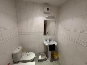 a white bathroom with a toilet and a sink at Cardiff City Escapes in Cardiff