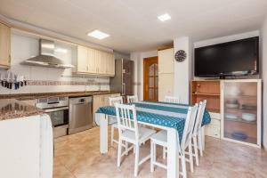 a kitchen with a table and chairs and a television at Malgrat in Malgrat de Mar +12 photos