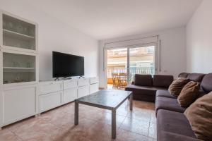 a living room with a couch and a tv at Malgrat in Malgrat de Mar